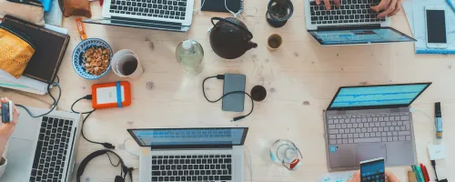 A bunch of laptops on a table from above